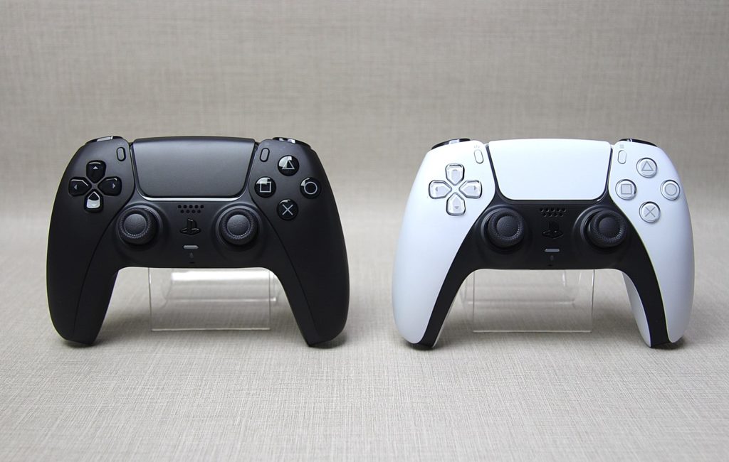 czarny i biały kontroler DualSense obok siebie
