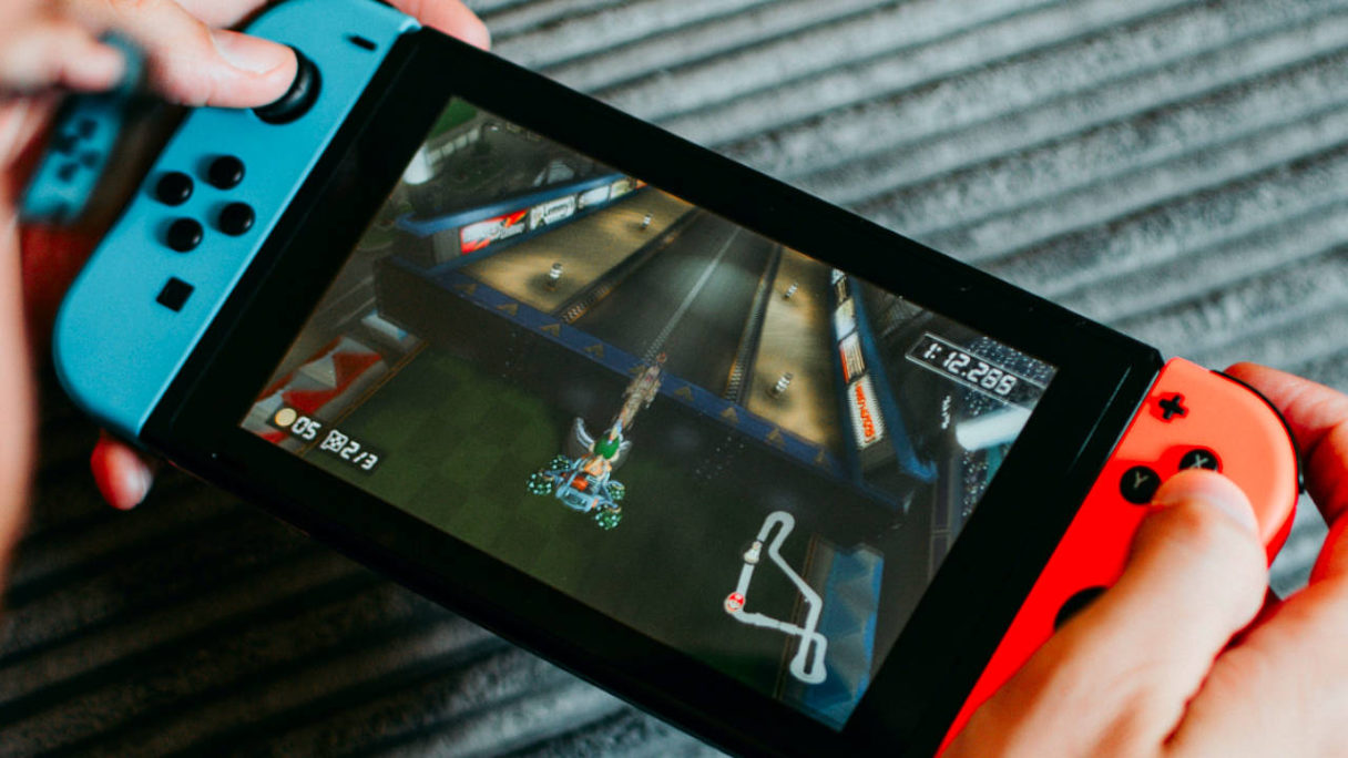 Nintendo Switch Joy Cony neon red/blue- mężczyzna gra w Mario Kart i dobrze mu idzie