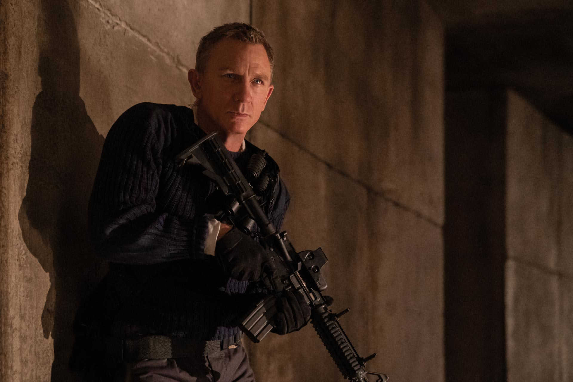 Daniel Craig uzbrojony w karabin szturmowy.