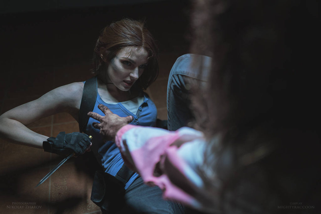 Resident Evil Cosplay - Jill Valentine leży na podłodze, a zombie usiłuje ją dorwać. Bohaterka trzyma nóż