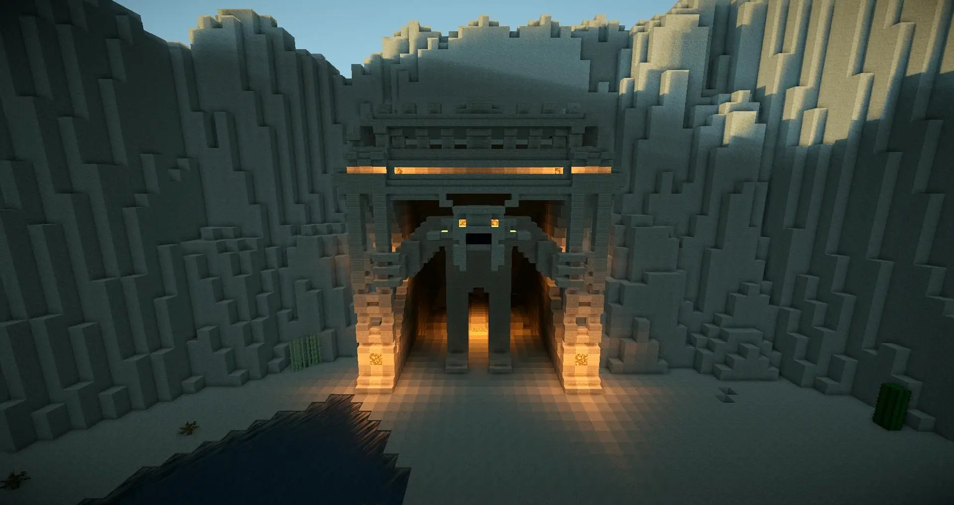 Minecraft cave entrance with lit path and stylized stone architecture.