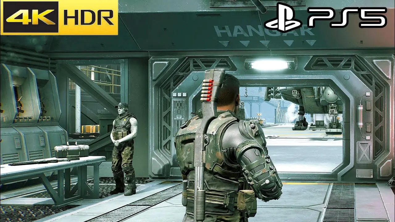 A first-person view of a Colonial Marine in armor standing in a futuristic hangar next to another soldier.